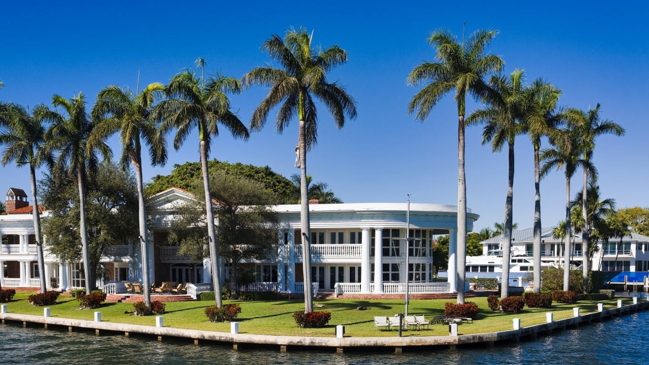 Elegant waterfront mansion with palm trees in Fort Lauderdale, Florida.